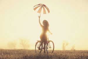 Girl with umbrella on a bike